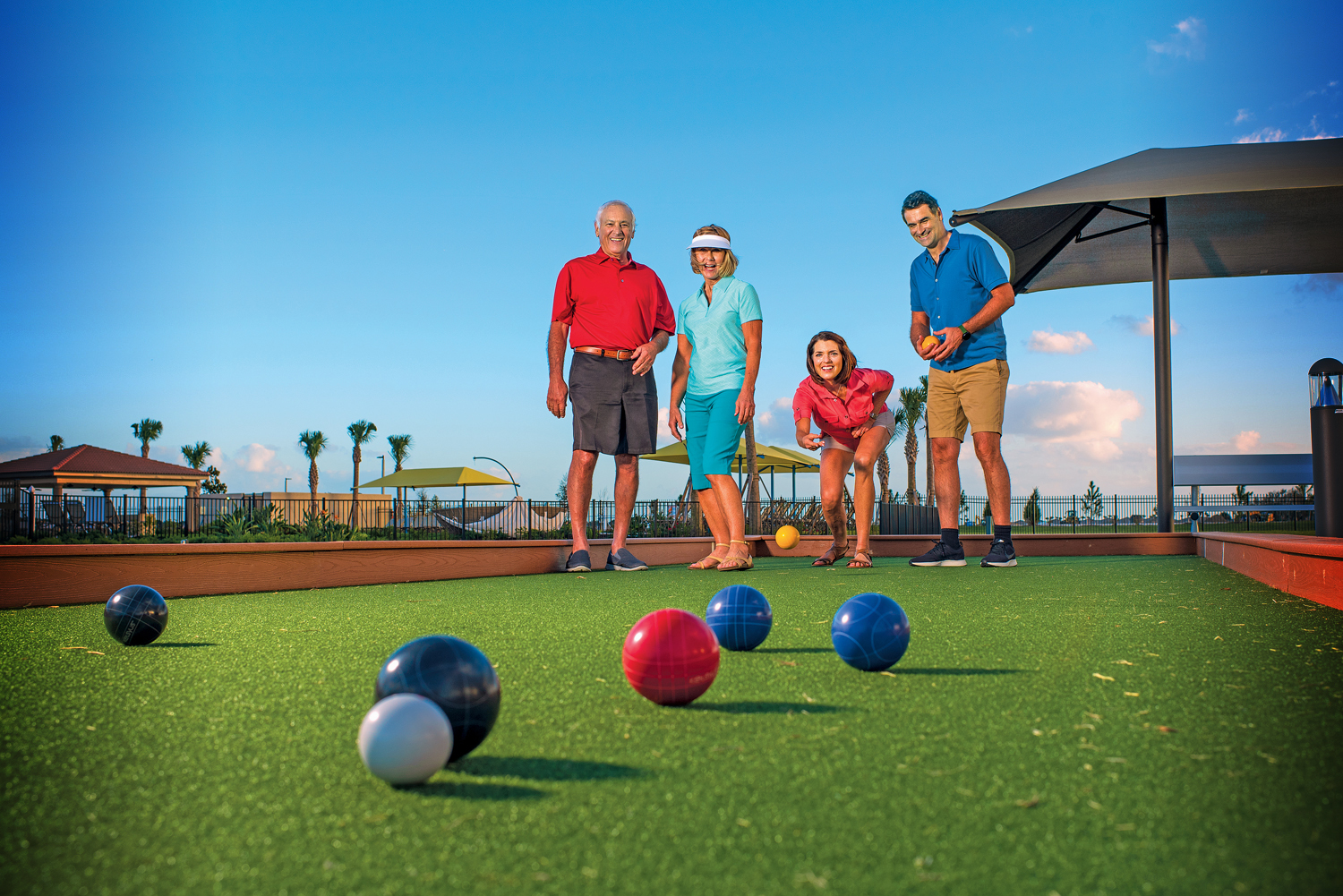 Two couples playing bocce ball.